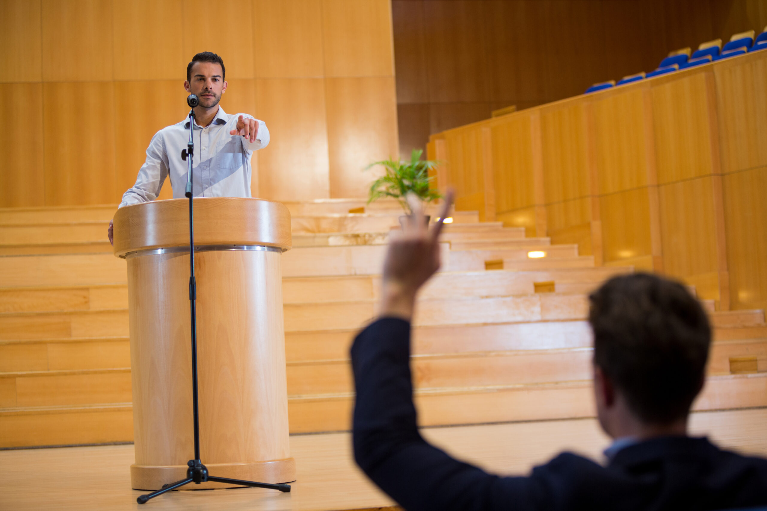 Business executive pointing towards audience while giving a speech